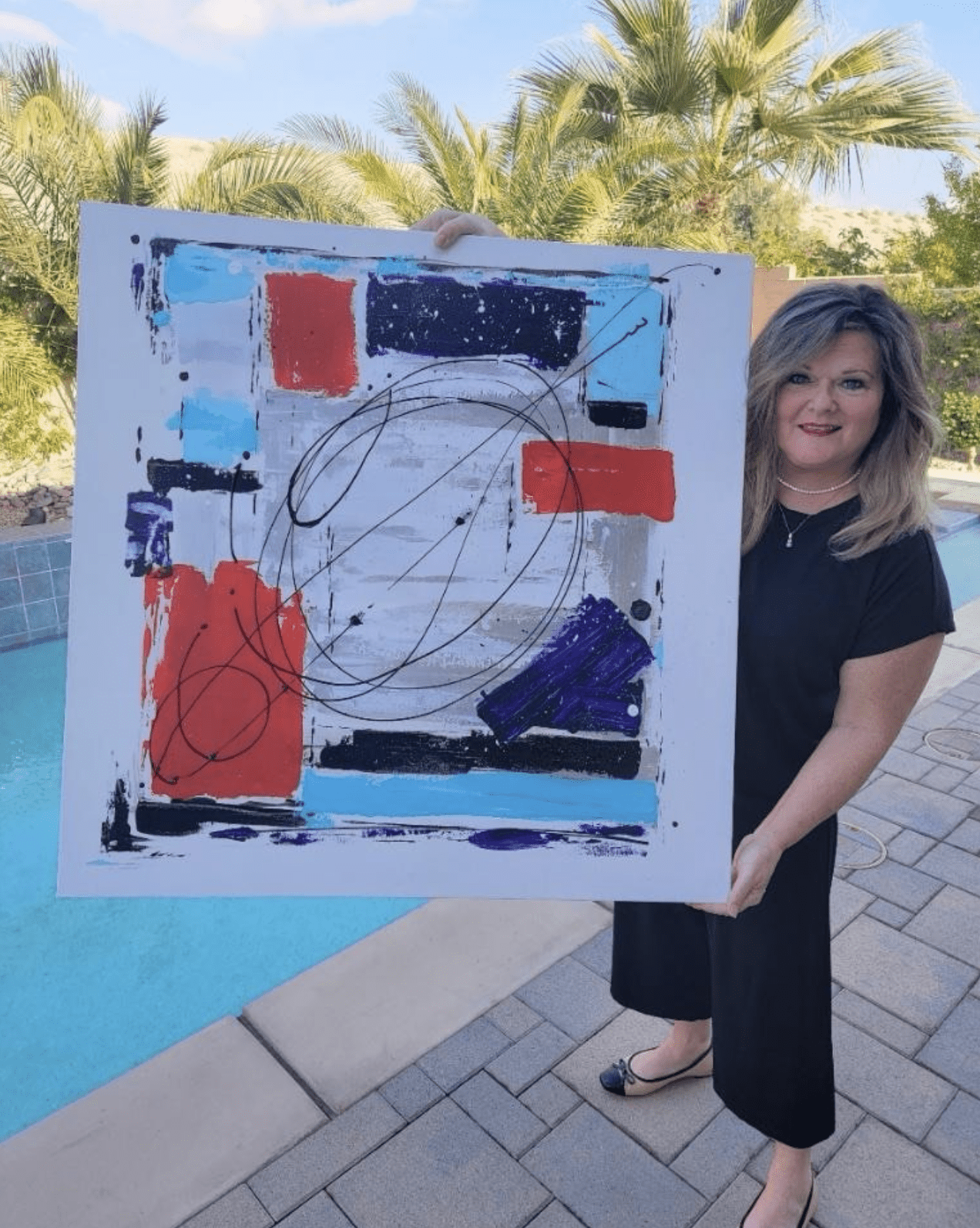 Thomas holding one of her paintings. Photo: Susan Masley Thomas